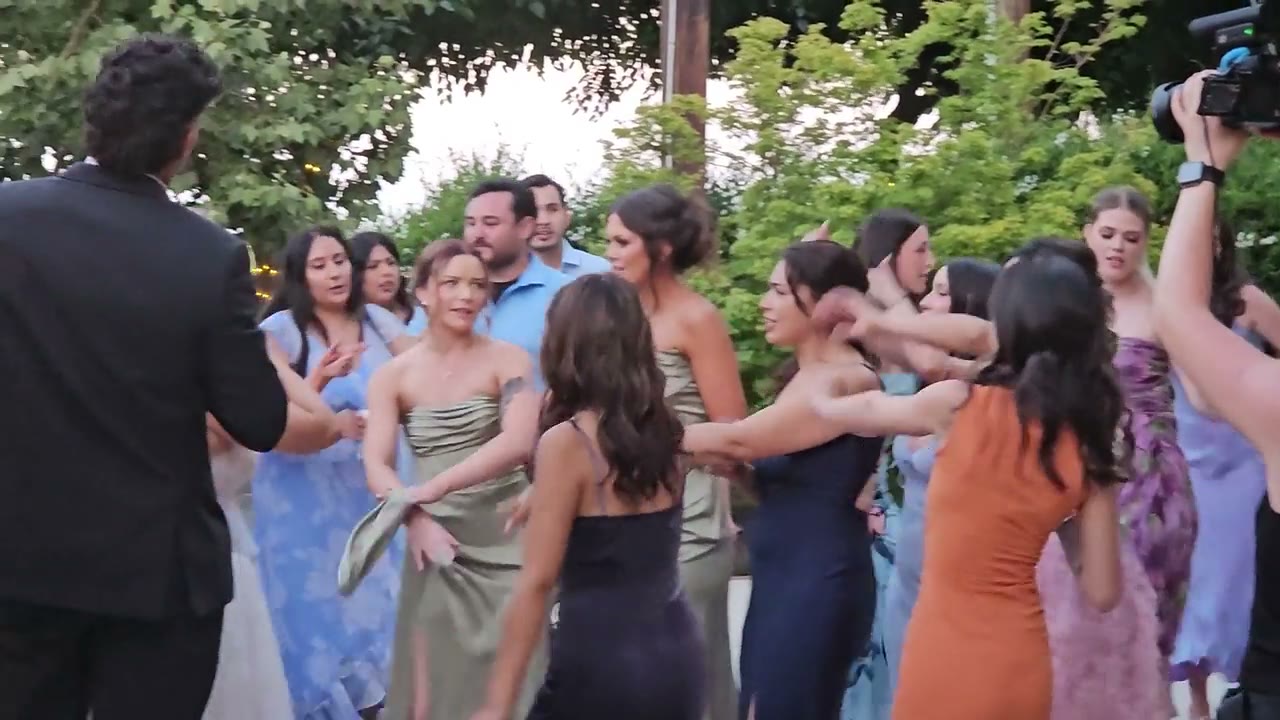 Wedding guests dancing outdoors at golden hour