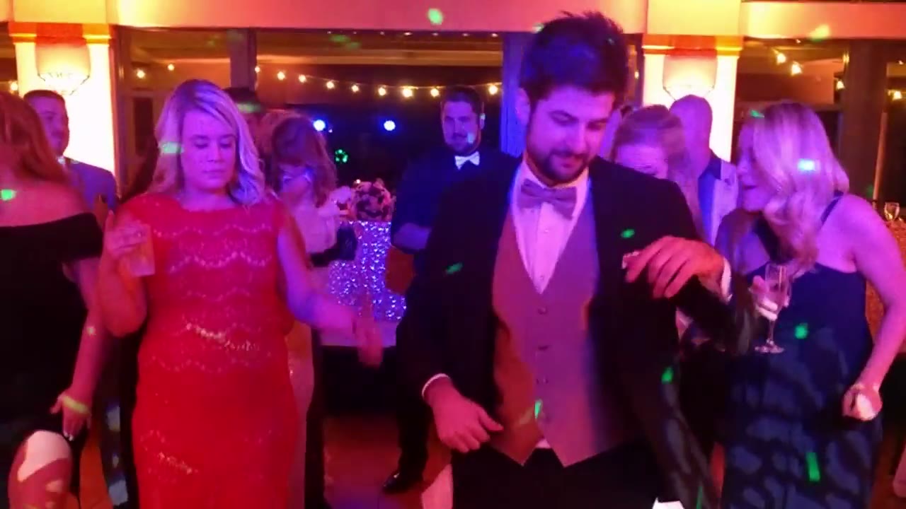 Wedding guests celebrating on the dance floor with confetti