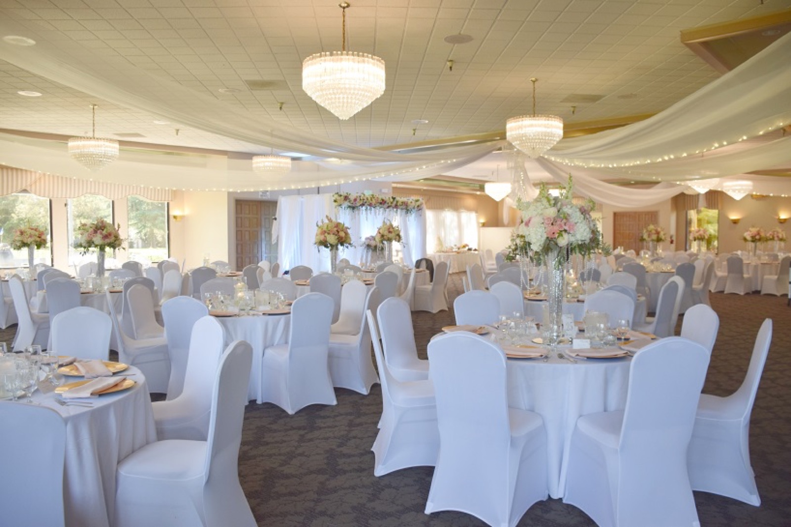 Chandelier-lit ballroom set for a wedding reception at Elkhorn Banquets in Stockton, California