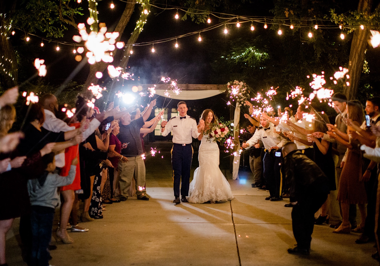 Reception dining tables set under string lights at Pageo Lavender Farm in Turlock, California