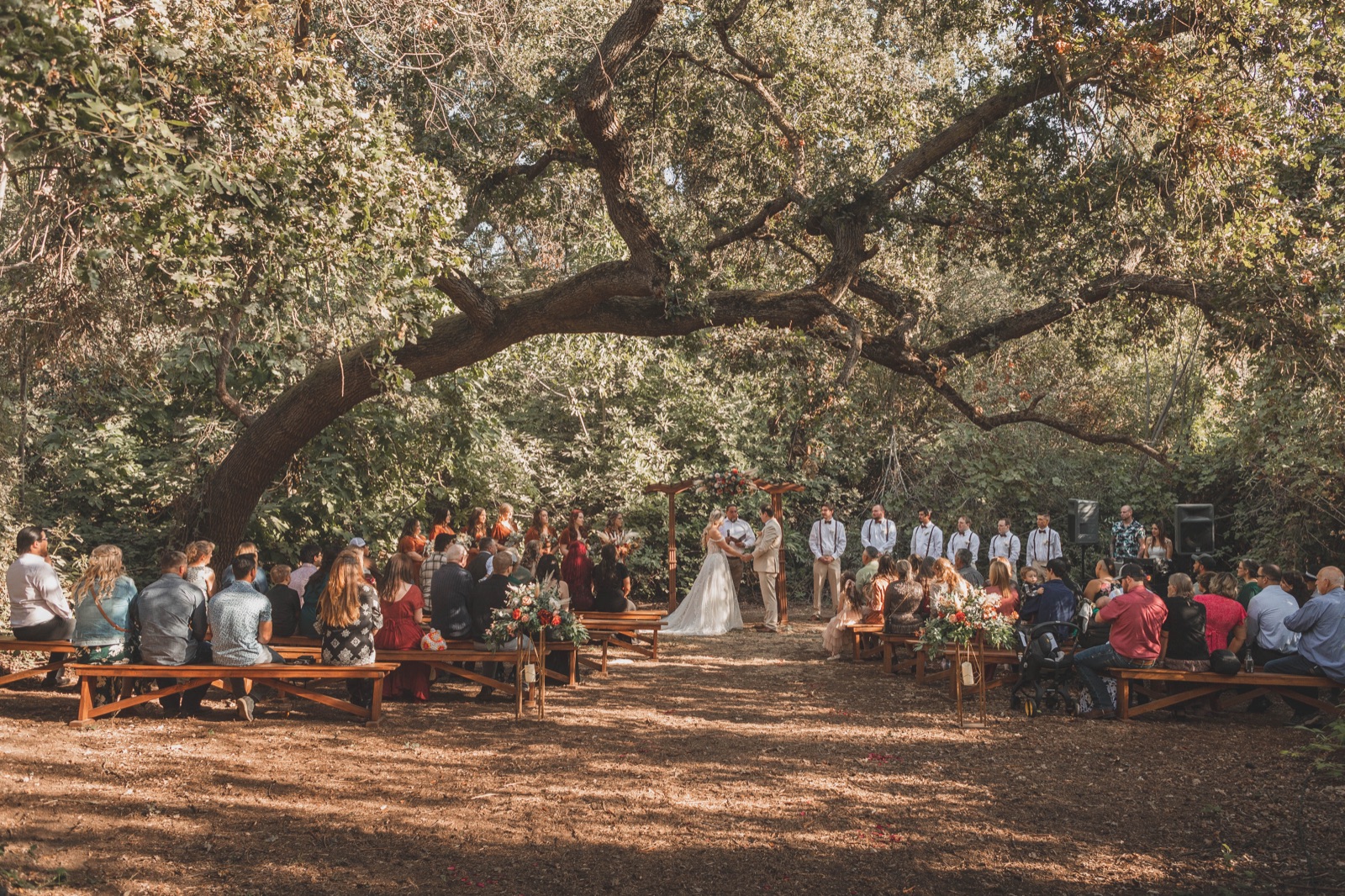 Outdoor reception setup among the oak trees at River Bottom Ranch in Sanger, California