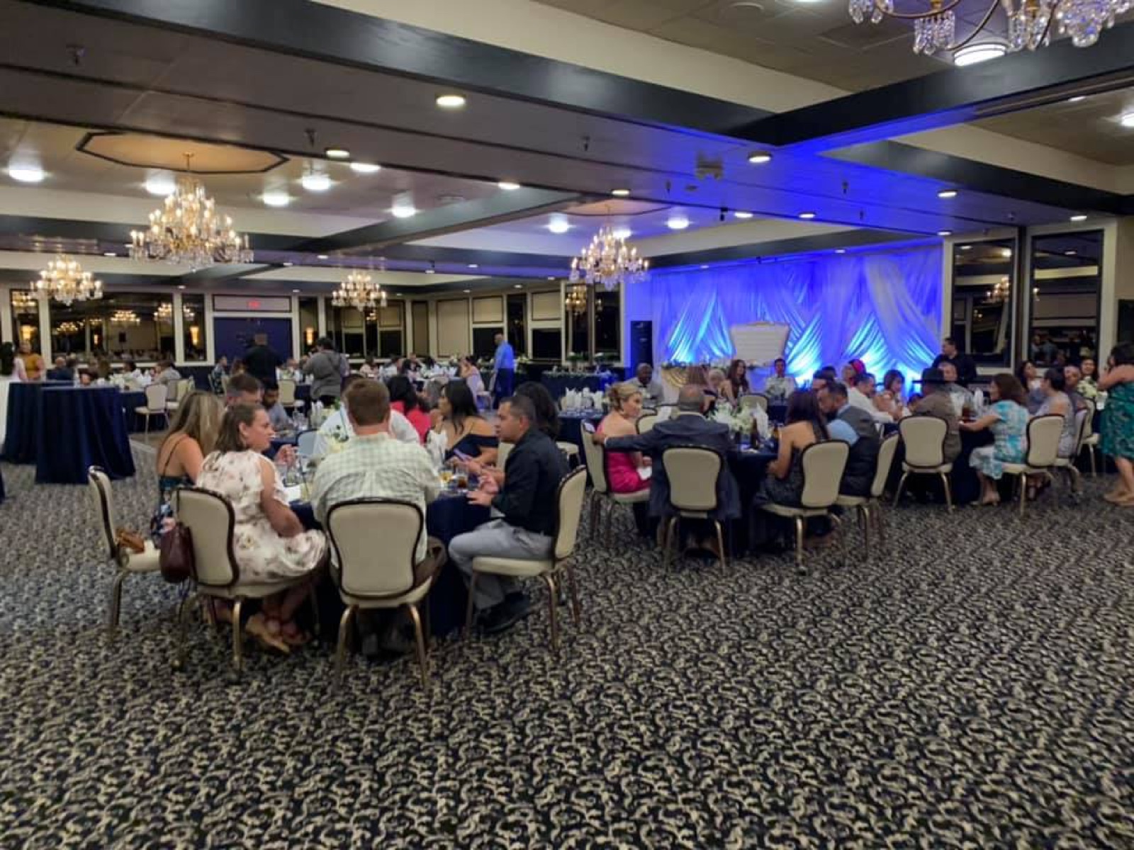 Banquet room with chandeliers set for a wedding reception at The Painted Table Event Center in Fresno, CA