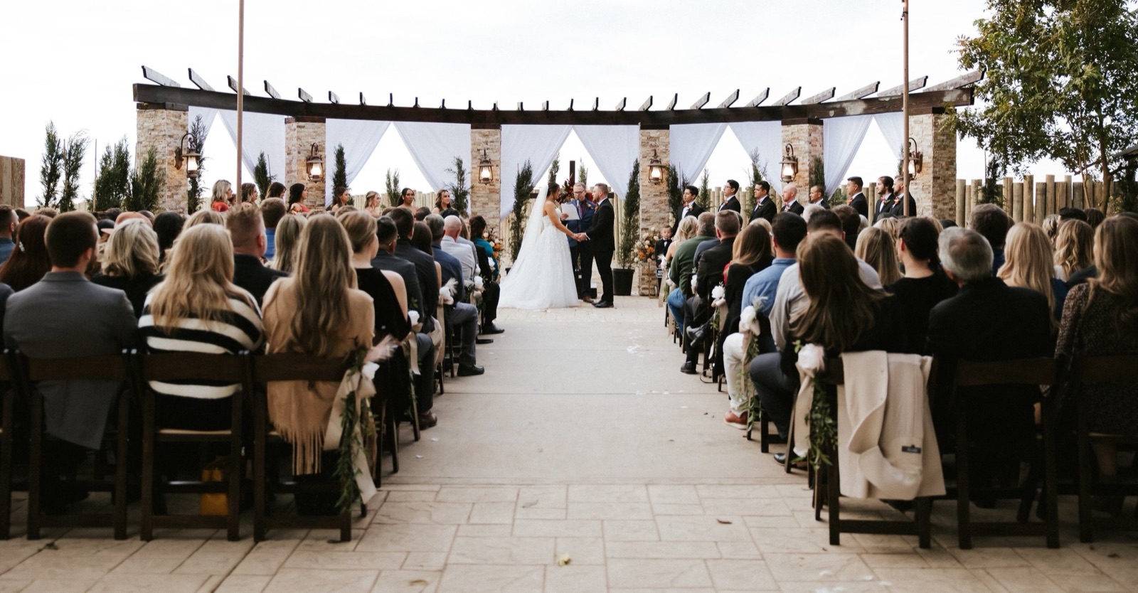 Garden ceremony site with floral archway at The Sunset Acres wedding venue in Fowler, California