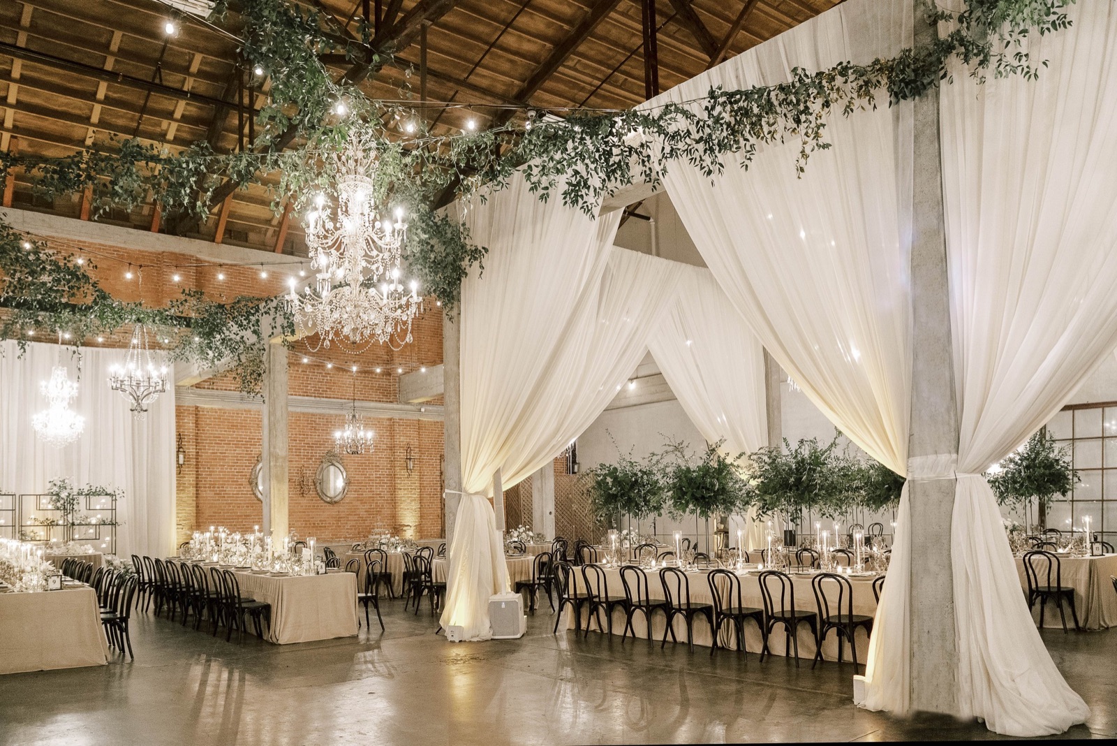 Reception space with draping and vintage chandeliers at The Willow Ballroom in Hood, California